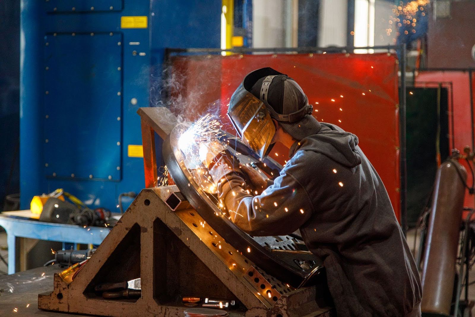 Custom metal fabrication welding project with sparks.